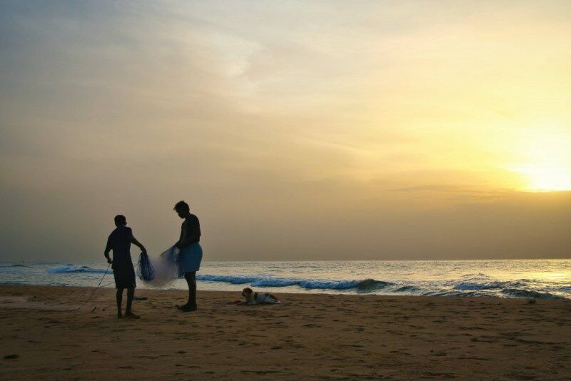 Fishermen preparing their nets at the beach.