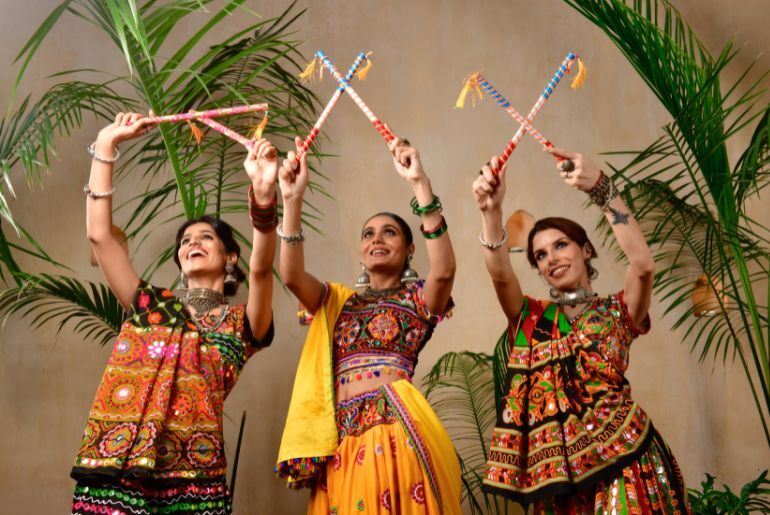 7 Garba And Dandiya Nights In Delhi-NCR To Book This Navratri 2 People performing Garba and Dandiya at a Navratri celebration in Delhi-NCR